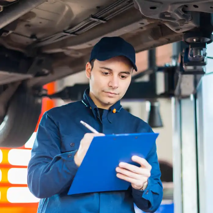 A Man In A Blue Uniform Stands Holding A Clipboard, Appearing Focused And Engaged In His Task.