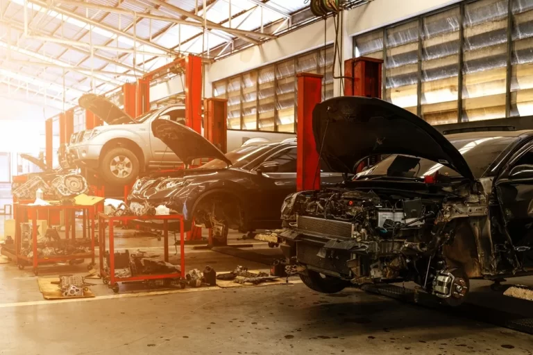 A Busy Car Repair Shop Featuring Multiple Vehicles On The Floor, Showcasing Tools And Equipment For Automotive Service.