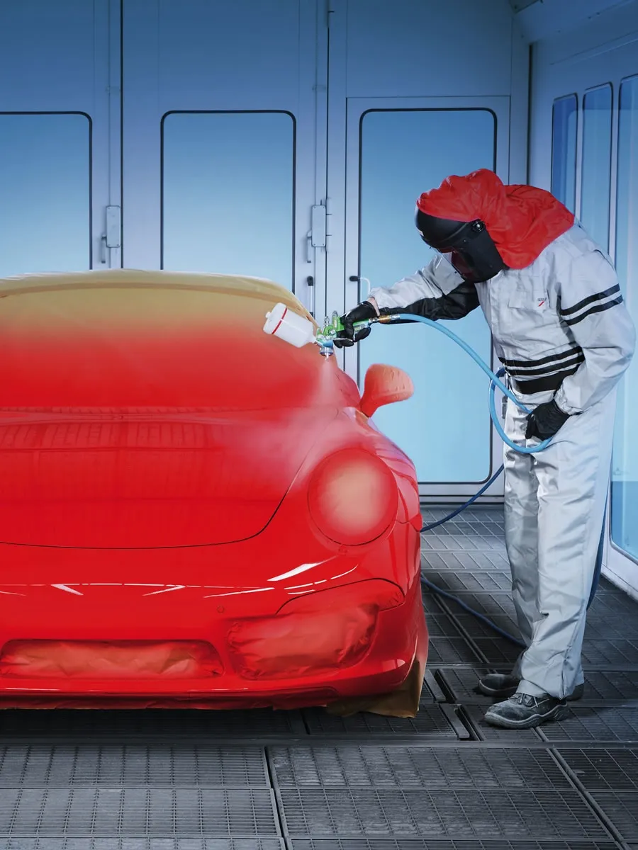 A Man Coloring A Car Wearing Protection Suit In Car Body Shop