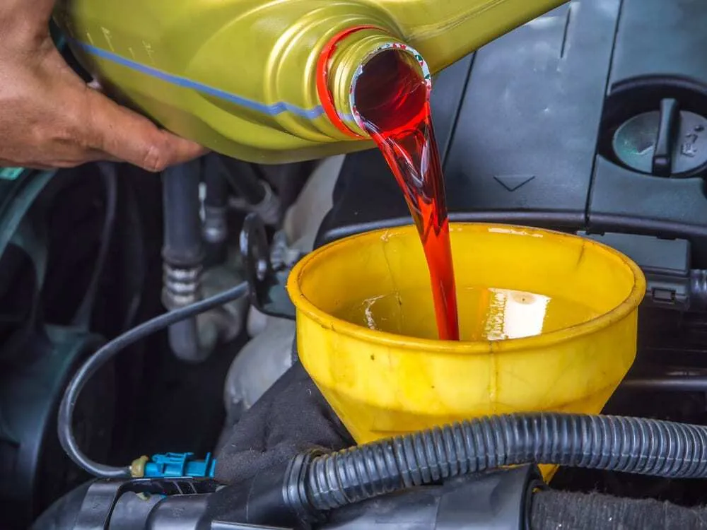 A Man Puting Oil In Tranmission Fluid